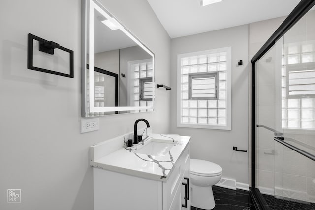 bathroom featuring vanity, toilet, and a shower with shower door