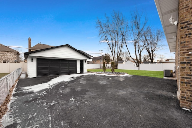 garage with a yard and central AC unit