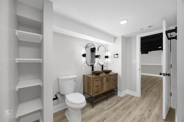 bathroom with hardwood / wood-style flooring, vanity, and toilet