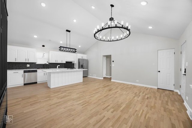 kitchen featuring white cabinetry, high vaulted ceiling, hanging light fixtures, and appliances with stainless steel finishes