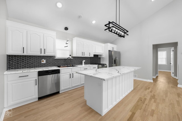 kitchen featuring pendant lighting, a center island, stainless steel appliances, and white cabinetry