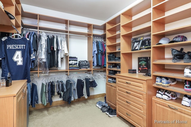 walk in closet featuring light colored carpet