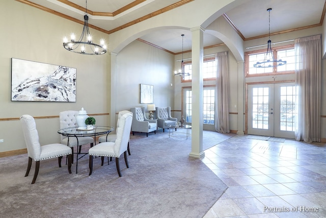 dining area with a wealth of natural light, ornamental molding, and french doors