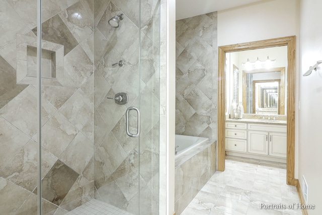 bathroom with vanity and shower with separate bathtub