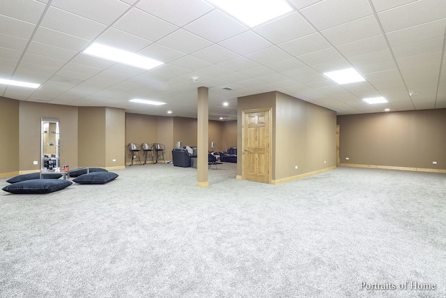 basement with carpet floors and a drop ceiling