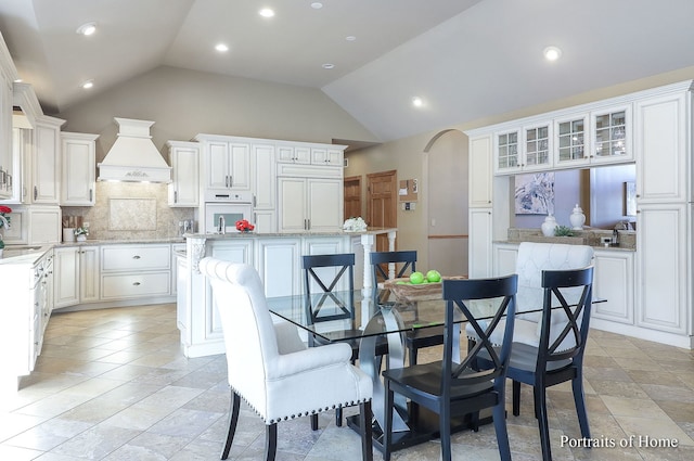 dining room featuring lofted ceiling and sink