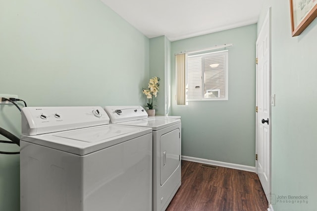 laundry area with washer and dryer and dark wood-type flooring