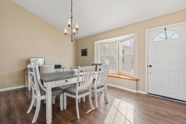 dining room featuring dark hardwood / wood-style floors, lofted ceiling, and a chandelier