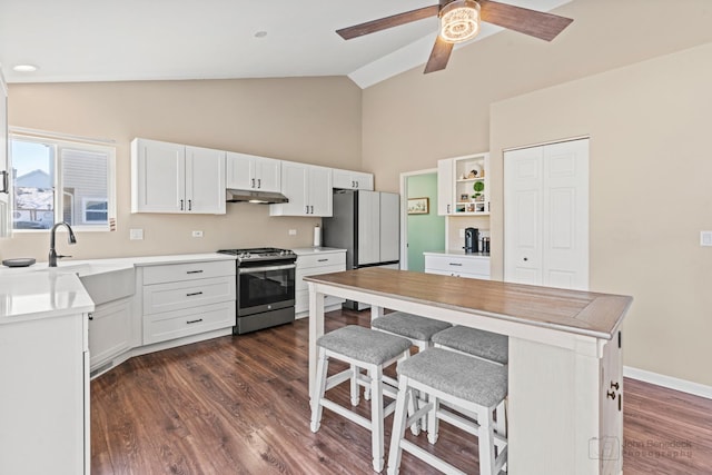 kitchen featuring white cabinets, appliances with stainless steel finishes, sink, and a breakfast bar area