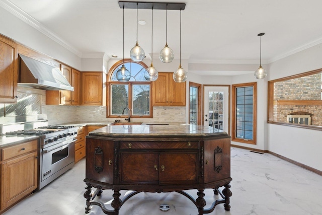 kitchen featuring wall chimney range hood, a center island, high end stove, and hanging light fixtures