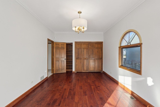 unfurnished bedroom with a notable chandelier, ornamental molding, and dark hardwood / wood-style flooring