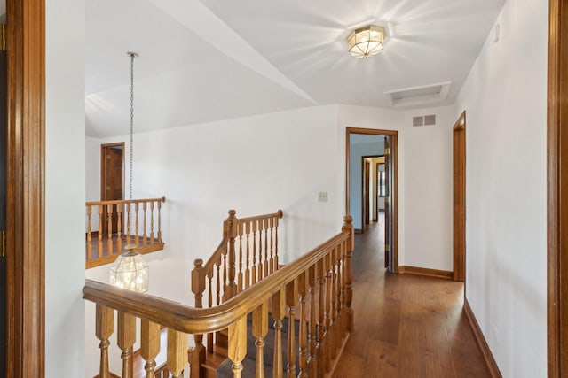 corridor with dark hardwood / wood-style flooring and vaulted ceiling