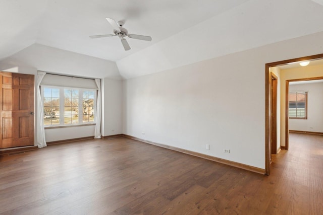 empty room with ceiling fan, wood-type flooring, lofted ceiling, and a healthy amount of sunlight