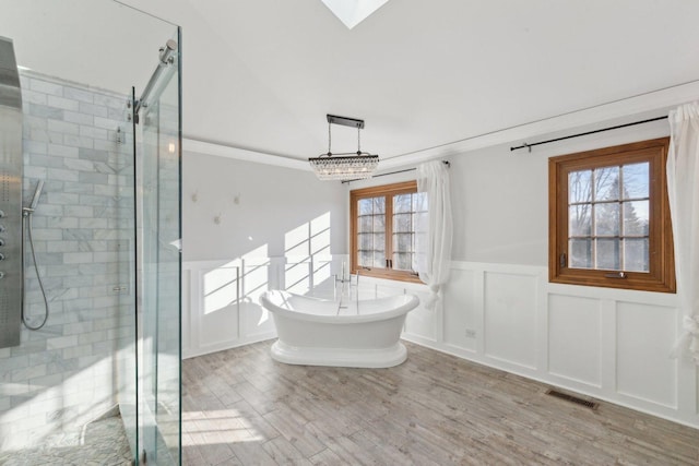 bathroom featuring independent shower and bath, crown molding, plenty of natural light, and wood-type flooring