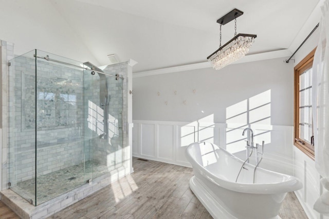 bathroom featuring independent shower and bath, crown molding, hardwood / wood-style flooring, an inviting chandelier, and vaulted ceiling