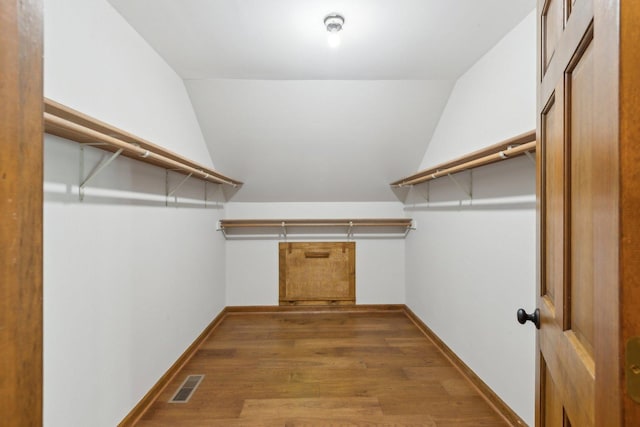 spacious closet with wood-type flooring and vaulted ceiling