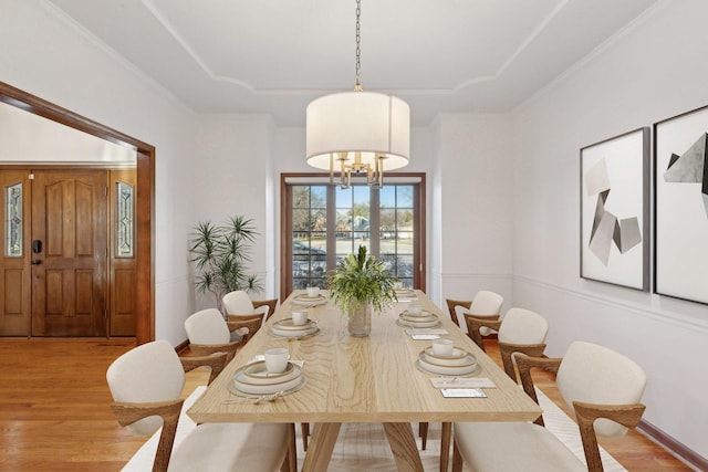 dining space with light hardwood / wood-style floors and a notable chandelier