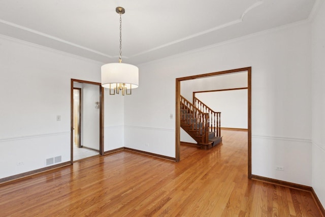 spare room featuring hardwood / wood-style flooring and ornamental molding