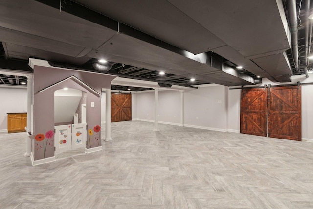 basement with light parquet floors and a barn door