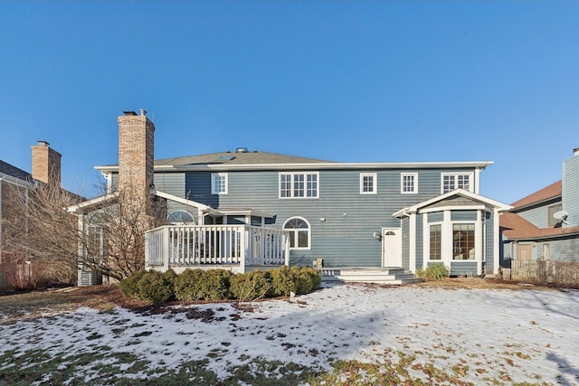 snow covered property with a deck