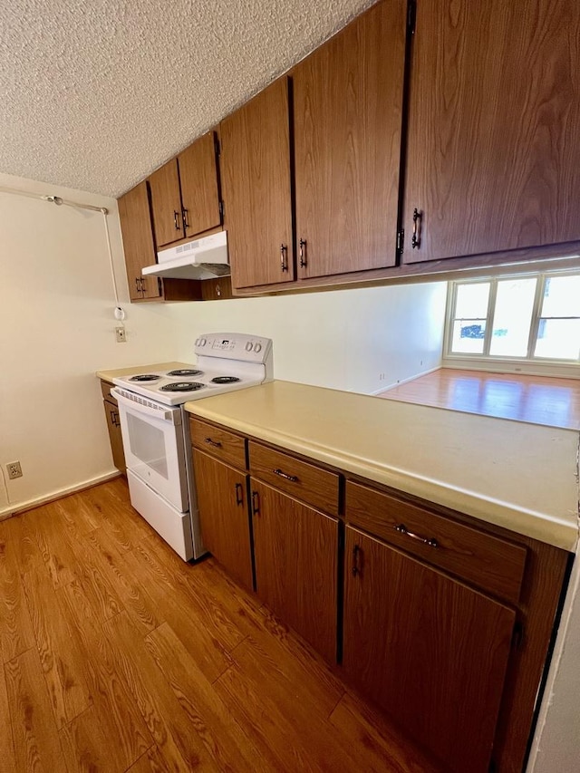 kitchen featuring white electric stove, a textured ceiling, and light hardwood / wood-style flooring