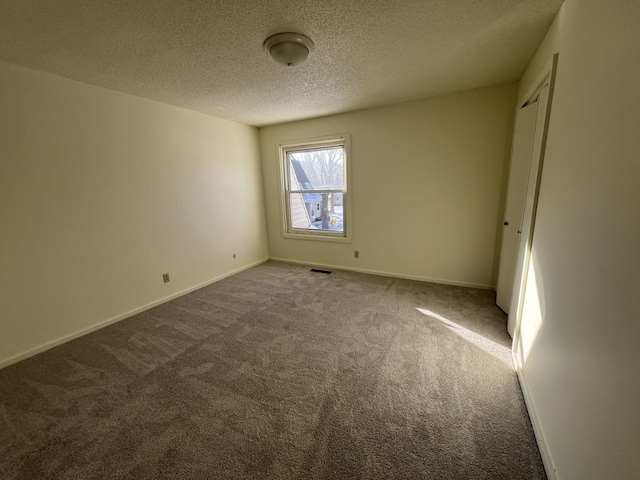 spare room featuring carpet and a textured ceiling