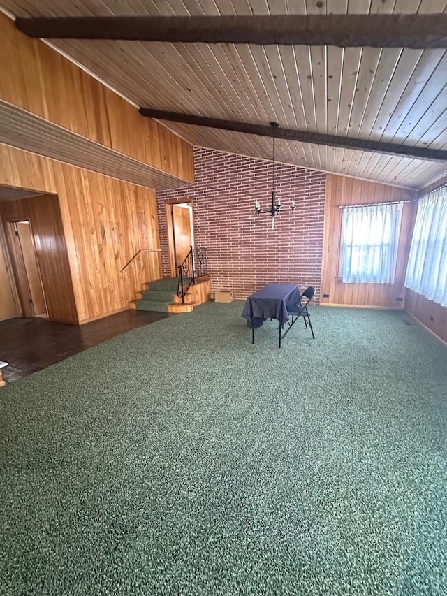 unfurnished room featuring carpet, a notable chandelier, wood ceiling, and wooden walls