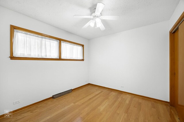 unfurnished room with a textured ceiling and light hardwood / wood-style flooring