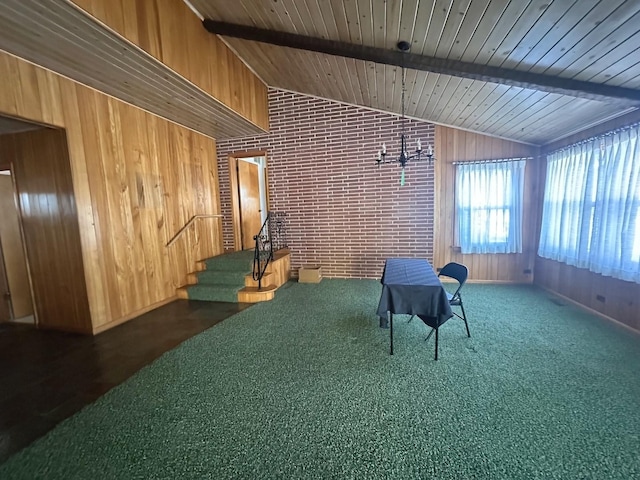 interior space with vaulted ceiling with beams, wood walls, dark colored carpet, and wooden ceiling