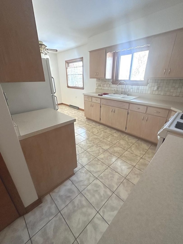 kitchen with tasteful backsplash, sink, plenty of natural light, light tile patterned flooring, and ceiling fan