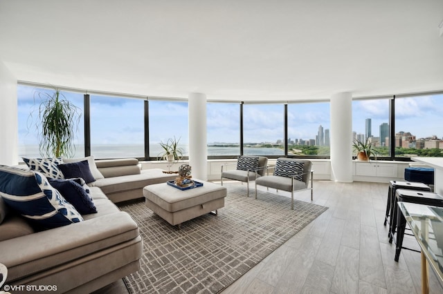 living room featuring a water view and light hardwood / wood-style floors