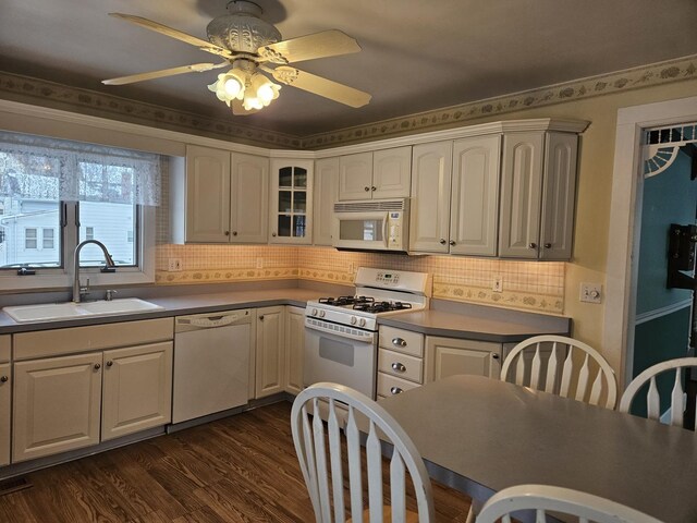 kitchen featuring ceiling fan, decorative backsplash, sink, white appliances, and dark hardwood / wood-style flooring