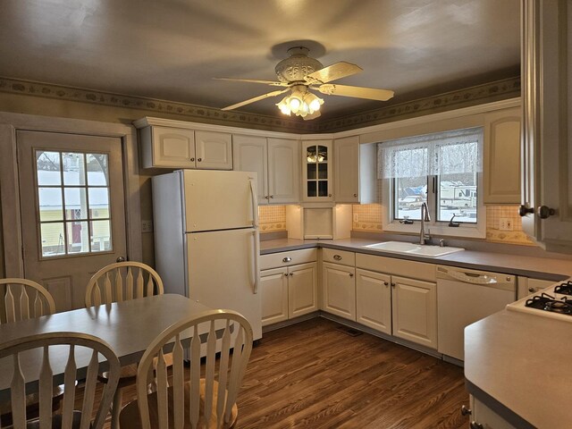 kitchen with white appliances, dark wood-type flooring, tasteful backsplash, sink, and ceiling fan