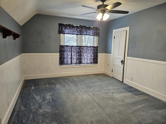 carpeted spare room featuring ceiling fan and vaulted ceiling