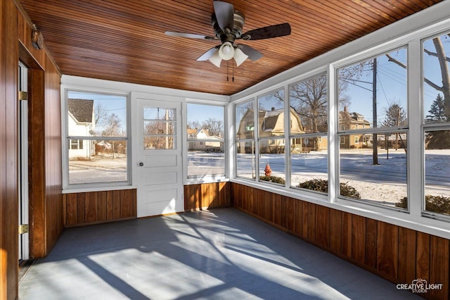 unfurnished sunroom featuring wood ceiling, a wealth of natural light, and ceiling fan