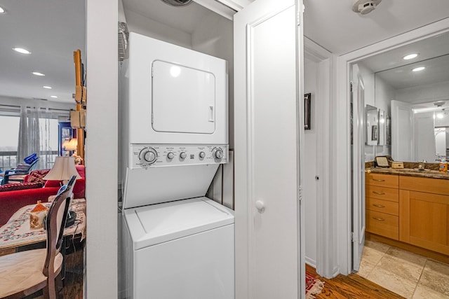 laundry area with sink and stacked washer / dryer