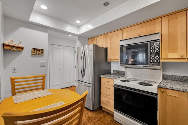 kitchen featuring range with electric stovetop, stainless steel fridge, dark hardwood / wood-style flooring, and light brown cabinets