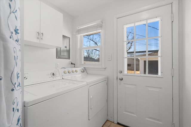 laundry room featuring washing machine and dryer, cabinets, electric panel, and light tile patterned floors