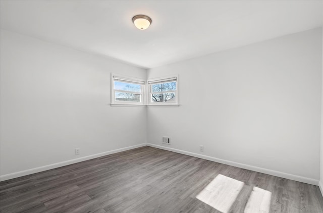 empty room with dark hardwood / wood-style flooring