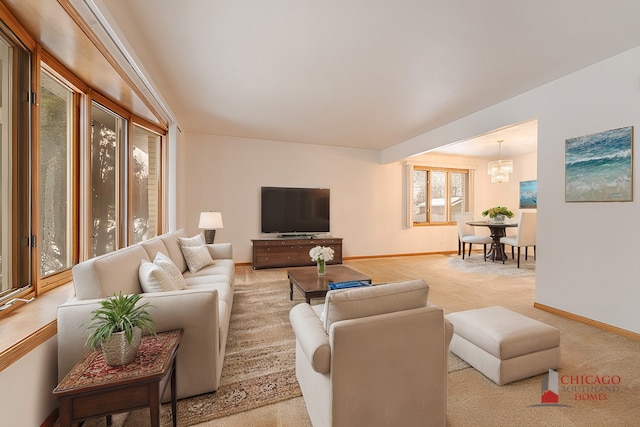 living room with light colored carpet and a notable chandelier