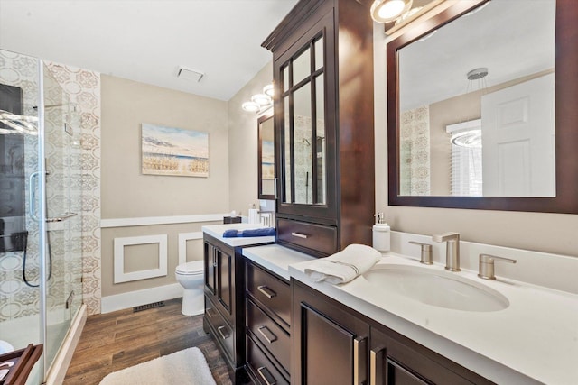 bathroom with a shower, wood-type flooring, vanity, and toilet