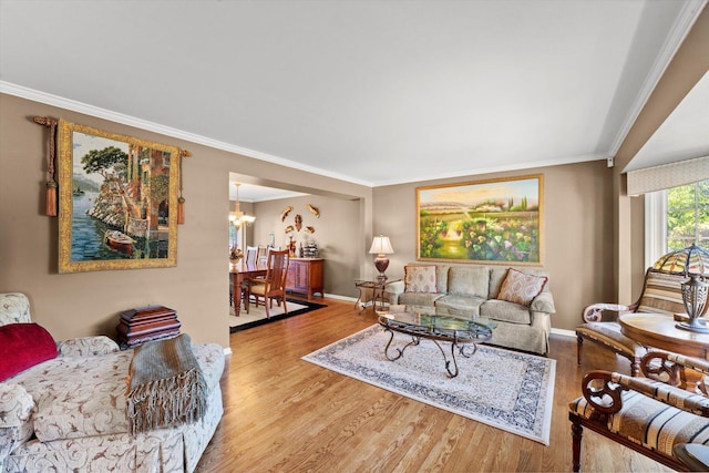 living room featuring hardwood / wood-style flooring, a notable chandelier, and crown molding