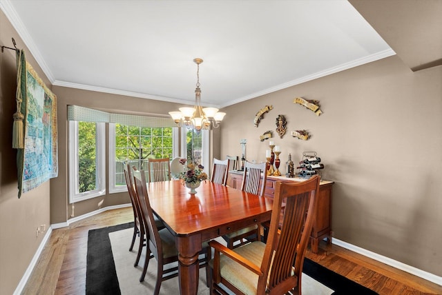 dining space featuring hardwood / wood-style floors, a chandelier, and ornamental molding