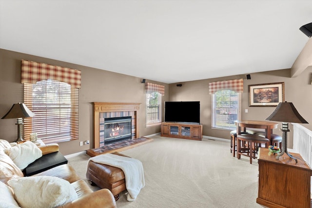 carpeted living room featuring a tile fireplace and a wealth of natural light