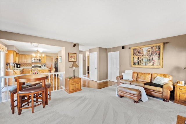 living room featuring light carpet, sink, and a chandelier