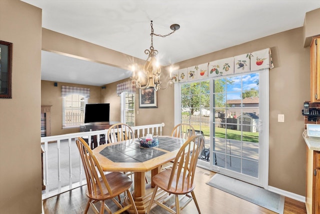 dining area featuring wood-type flooring and an inviting chandelier