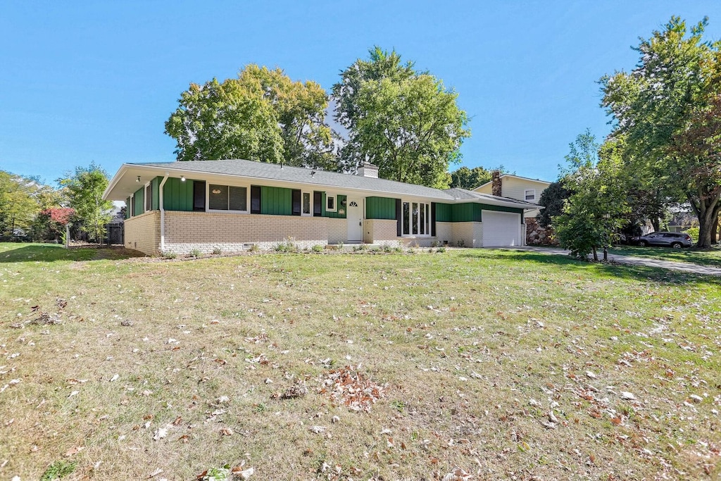 ranch-style house with a garage and a front lawn