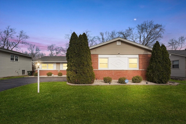 ranch-style home featuring a lawn