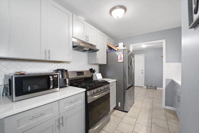 kitchen featuring white cabinetry, light stone countertops, light tile patterned floors, and appliances with stainless steel finishes