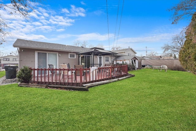 rear view of house featuring a wooden deck and a lawn